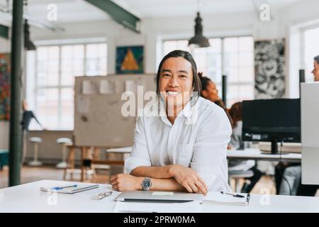 Porträt eines lächelnden Geschäftsmannes am modernen Arbeitsplatz Stockfoto