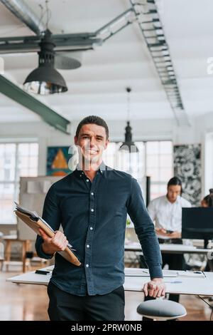 Porträt eines lächelnden Geschäftsmannes mit Akten im Büro Stockfoto