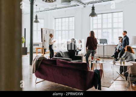Männliche und weibliche Geschäftsleute, die an einem Meeting mit dem Manager im Büro teilnehmen Stockfoto