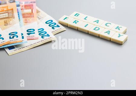 Schwarzer freitagstext und Euro-Geld auf grauem Hintergrund. Stockfoto