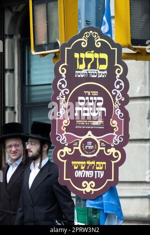 Ein kunstvoll verziertes Schild in Jiddisch und Hebräisch verkündet ein Gemeindetreffen zur Ehren des Sabbats. Die Eruv sollte das Diskussionsthema sein. Stockfoto