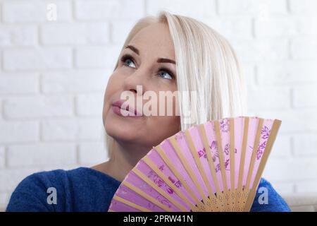 Reife Frau mit Hitzewallungen aus der Menopause Stockfoto