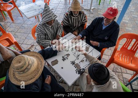 Eine Gruppe von Männern, die auf der Terrasse einer Bar in Oued Laou Karten spielen. Stockfoto