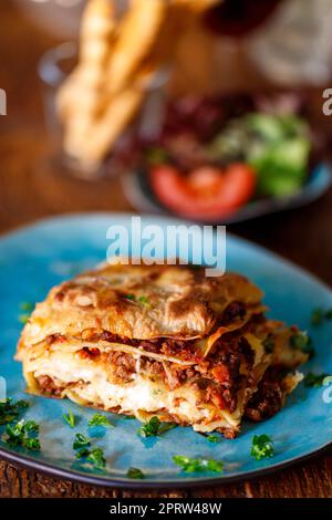 Lasagne auf einem blauen Teller Stockfoto