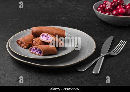 Dünne Schokoladen-Pfannkuchen gefüllt mit Hüttenkäse, Blaubeere und Kirsche Stockfoto