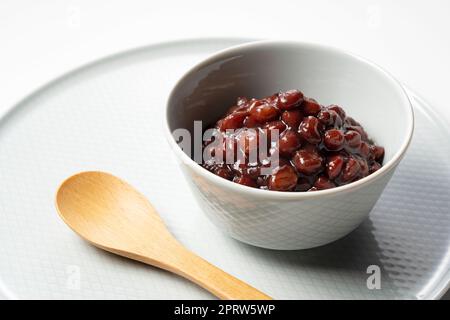 Gekochte Azuki-Bohnen auf weißem Hintergrund. Stockfoto