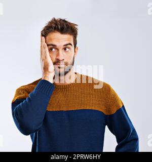 Mein Schlechtes. Studio-Aufnahme eines jungen Mannes, der vor grauem Hintergrund bedauernd aussieht. Stockfoto