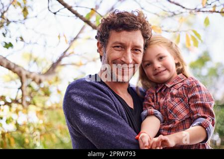 Die ersten Zeichen des Herbstes. Ein kleines Mädchen und ihr Vater im Herbst im Garten. Stockfoto