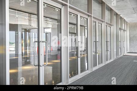 Drehtüren. Die Fassade eines modernen Einkaufszentrums oder Bahnhofs, ein Flughafen mit Drehtüren. Stockfoto