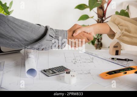 Erfolg des Architektenteams und Handshaking nach Treffen Beratung und Arbeit für Architekturbauprojekt mit Partnerbearbeitung auf Blaupause-Papier p Stockfoto