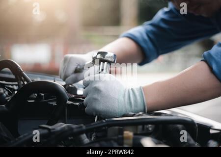 Service im Freien. Nahaufnahme Hände von Auto-Mechaniker Mann arbeiten an der Auto-Motor mit Schlüssel zu reparieren und Wartung, kaputte Auto Pflege überprüfen und repariert die Stockfoto