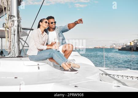 Paare, Liebe und Yacht mit einem Mann und einer Frau auf dem Meer oder auf dem Meer für Romantik und ein luxuriöses Date oder eine Bootstour. Glücklich, vertrauensvoll und fürsorglich mit einem jungen Mann und einer jungen Frau auf einem Boot im Wasser zusammen Stockfoto