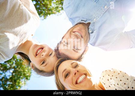 Nehmen Sie sich mehr Zeit für das, was am wichtigsten ist. Porträt einer dreiköpfigen Familie, die auf die Kamera schaut. Stockfoto