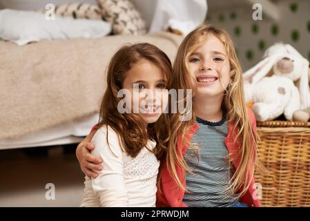 Beste Freunde für immer. Portrait von zwei kleinen Mädchen, die in Innenräumen Zeit miteinander verbringen. Stockfoto