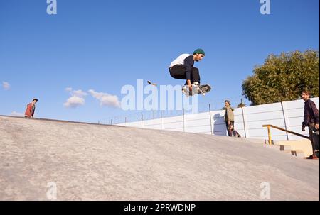 Luft holen. Ein junger Mann macht Tricks auf seinem Skateboard im Skatepark. Stockfoto