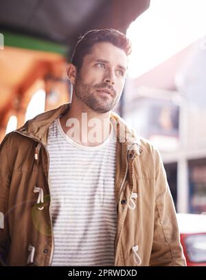 So viele Dinge zu sehen. Ein modischer junger Mann, der durch die Stadt schlendert. Stockfoto