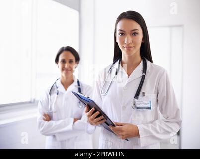 Vertrauen Sie ihren fähigen Händen. Porträt eines selbstbewussten jungen Doktoren. Stockfoto