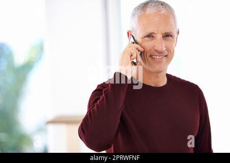 Mit Freunden und Familie in Kontakt bleiben. Ein reifer Mann, der ein angenehmes Telefongespräch führt. Stockfoto