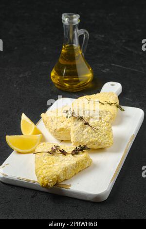 Halbfertige gefrorene Fischschnitzel in Panade Stockfoto