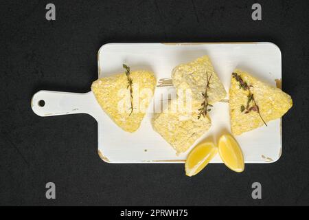 Overhead View von halbfertigen gefrorenen Fischschnitzeln bei der Panade Stockfoto