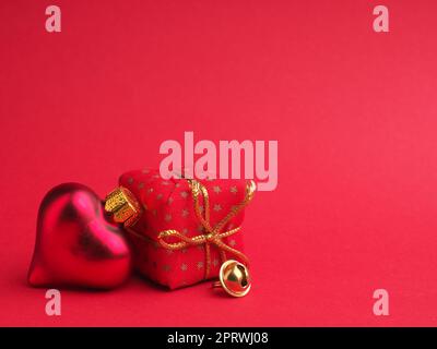 Herzförmige Weihnachtskugel im Vintage-Stil auf rotem Hintergrund mit Platz für Ihren Text oder Ihr Bild Stockfoto