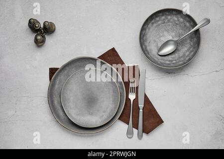 Set aus grauen Keramikplatten und Geschirr, Draufsicht Stockfoto