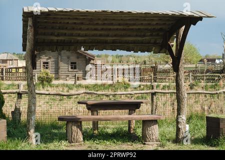 Ein alter Holzpavillon zum Entspannen im Park. Ausgestattet mit Holztischen und -Bänken. Stockfoto