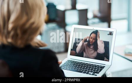 In Zeiten der Unsicherheit halten Sie an der Lebensader fest. Eine junge Frau, die mit einem Videokonferenzwerkzeug eine Beratungssitzung mit einem Psychologen führt. Stockfoto