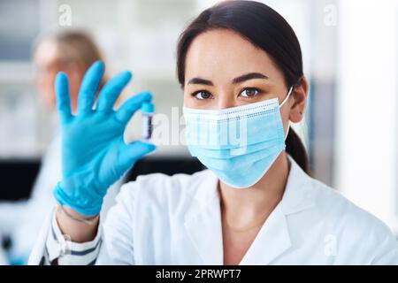 Diese Behandlung ist bereit, sich einer Erprobung zu unterziehen. Porträt eines jungen Wissenschaftlers, der Proben im Labor analysiert. Stockfoto