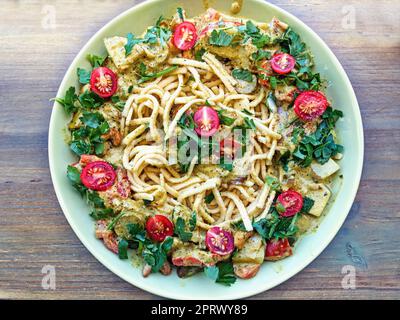 Gemüse-Curry mit Kräutern auf Spaetzle als Teller Stockfoto