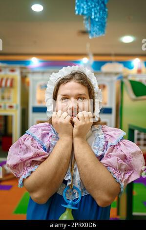 Lustiger Mann wie kleines Baby, der den Affen spielt Stockfoto