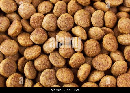 Draufsicht der braunen Kibbelstücke von trockener Hundefutter-Textur in Nahaufnahme. Stockfoto