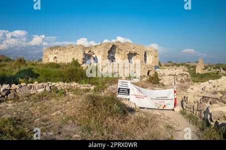 Ein Schild warnt die Menschen vor möglichen Baueinstürzen im byzantinischen Krankenhaus und anderen unausgegrabenen Ruinen in der antiken römischen Stadt Side in Antalya Stockfoto