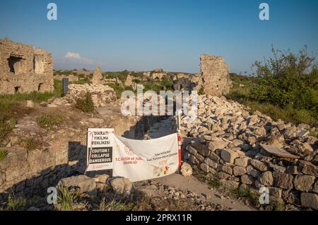 Ein Schild warnt die Menschen vor möglichen Baueinstürzen im byzantinischen Krankenhaus und unausgegrabenen Ruinen in der antiken römischen Stadt Side in Antalya Provin Stockfoto