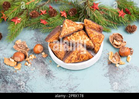 Nuss-Eckdreiecke, traditionelle deutsche Süßwaren namens Nussecke, mit Schokolade überzogen, weihnachtskuchen Stockfoto