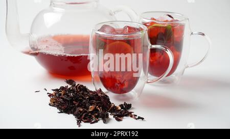 Hibiscus kaltes Teetrink mit Eiswürfeln und Zitrone im Glas Stockfoto