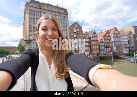 Schöne junge Frau, die in Hamburg Selfie-Fotos mit dem Smartphone macht Stockfoto