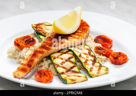 Gegrilltes Geflügelfleisch mit Tomaten Zucchini serviert mit Couscous Stockfoto