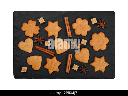 Lebkekse und Gewürze auf schwarzem Schiefer Stockfoto