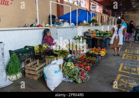 Eine einheimische Frau aus Zapotec in traditionellen Kleidern, die frische Produkte auf dem Markt in Tlacolula de Matamoros, Oaxaca, Mexiko, verkauft. Stockfoto