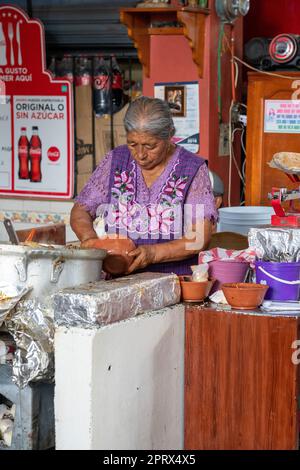 Eine einheimische zapotekische Frau in traditionellen Kleidern kocht auf dem Markt in Tlacolula de Matamoros, Oaxaca, Mexiko. Stockfoto