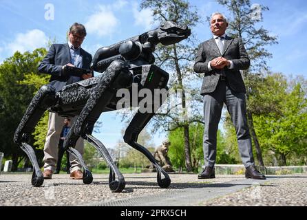 Stuttgart, Deutschland. 27. April 2023. Thomas Strobl (CDU, r), Innenminister von Baden-Württemberga, und Klaus Lison, Mitglied des Direktorats Sondereinsatzkräfte des Polizeihauptquartiers in Göppingen, stehen bei einer Presseveranstaltung hinter einem Roboter. Nach guten Erfahrungen aus Nordrhein-Westfalen hat die Polizei von Baden-Württemberg einen so genannten Wanderroboter des Typs „Spot“ von der amerikanischen Firma Boston Dynamic erworben. Kredit: Marijan Murat/dpa/Alamy Live News Stockfoto