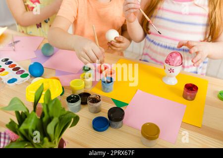 Süße Kinder malen zu Hause Ostereier. Kinder bereiten sich auf ostern vor. Draufsicht Stockfoto