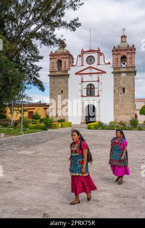 Zwei einheimische Zapoteken in traditionellen Kleidern vor der Kirche in Tlacolula de Matamoros, Oaxaca, Mexiko. Stockfoto