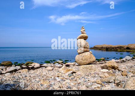 Steinpyramide auf dem Abschnitt der Westküste des Lands Hammeren an der Nordspitze der Insel Bornholm, genannt Stentarne Strand, Dänemark. Stockfoto