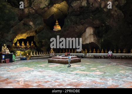 Die Hauptkammer der Tham Khao Luang Höhle mit mehreren kleinen Figuren gegenüber der zentralen Buddha-Statue, etwa 50 Meter hoch, ist eine mehrkammerige Höhle, die von den Königen der königlichen Rattanakosin-Dynastie in der Provinz Phetchaburi genutzt wurde. Die Tham Khao Luang Höhle, eine Höhle mit Stalaktiten, einer der beeindruckendsten Höhlenschreine Thailands, ist voller Buddha-Bilder und war schon immer ein wichtiger Meditationsort, auch nicht weit von Bangkok entfernt, sie ist eines der meistbesuchten Touristenziele von Thais und ausländischen Reisenden. Stockfoto