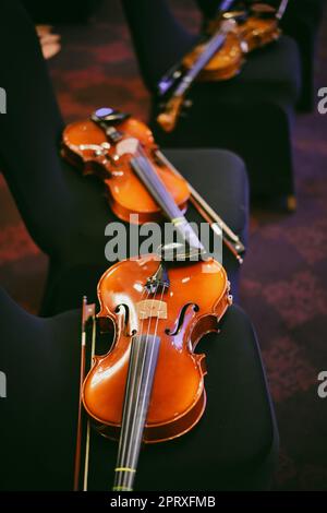 Detailansicht von zwei Violinen auf einigen Stühlen. Stockfoto