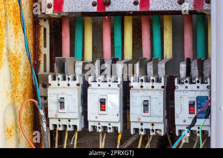 DUSCHANBE, TADSCHIKISTAN - 12. AUGUST 2022: Viele alte rostige elektrische Sicherungskästen mit Elektrokabeln. Stockfoto