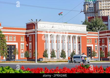 DUSCHANBE, TADSCHIKISTAN - 12. AUGUST 2022: Rotes Gebäude des Parlaments der Republik Tadschikistan auf der Rudaki Avenue im Sommer vor dem blauen Himmel. Stockfoto