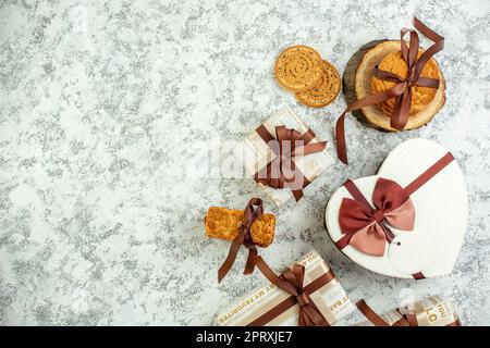 Blick von oben Valentinstag Geschenke Kekse gebunden mit Band herzförmigen geschenkbox auf grauem Tisch Copy Place Stockfoto